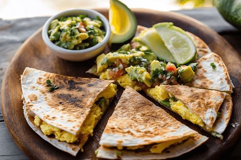 Quesadilla with Soft Scrambled Eggs and Avocado Salsa: Discover a delicious breakfast recipe filled with soft scrambled eggs, crispy bacon, chipotle peppers, and melted cheese, all wrapped in a flour tortilla and served with a fresh avocado and cilantro lime salsa. Perfect for a quick, healthy, and flavorful breakfast any day of the week. Healthy Mexican Breakfast Recipes, Cilantro Lime Salsa, Breakfast Quesadilla Recipes, Soft Scrambled Eggs, Eggs And Avocado, Avocado Nutrition, Mango Pineapple Smoothie, Breakfast Quesadilla, Mexican Breakfast Recipes