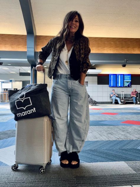 Woman posing at the airport dressed in barrel leg jeans, white shirt, black vest, and black sandals. Puddle Jeans Street Style, Barrel Denim Outfit, Baloon Jeans Styling Women, Barrel Jeans Outfit Spring, Diy Barrel Jeans, Barrel Jeans Outfit Street Style, Ballon Jeans Outfits, Styling Barrel Jeans, Barrel Leg Pants Outfit