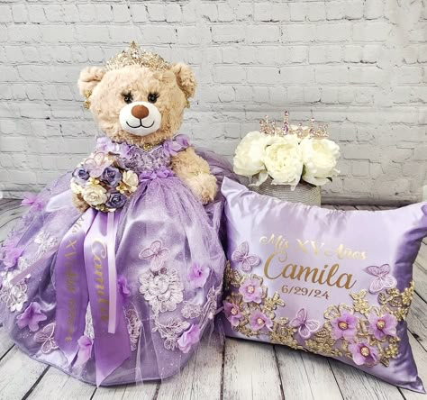 Packages: Complete package includes: 🧸 Quinceanera Bear or Doll (Includes bear or doll, Dress, Petticoat, Jewelry, Metal Tiara, Bouquet, Doll stand, Personalized ribbon) 👸🏻 Tiara upgrade for Bear/Doll  🧸 Doll stand for the Bear/Doll  ️ Kneeling Pillow  👸 Tiara Pillow 📖 Guest Book 🖋️ Pen 📕Bible 🕯️Candle 📷Photo Album 💵Card/Money Box (Acrylic also available for additional cost) 🥂🍾Small Brindis Champagne Set (2 glasses & 1 bottle) 🍰Cake Serving Set ✍🏻 Personalization on items ✍🏻 Ribbon Personalization for Bear  Complete package PLUS includes:  ☝️everything above PLUS Large Brindis champagne set instead of small (16 glasses & 1 bottle)  💐Bouquet **Please indicate metal color (gold, silver or Rosegold), fabric, ribbon and tule colors, etc. **Date of the quinceanera * Name and da Quince Bear Purple, Rapunzel Quinceanera Theme, Quinceanera Bear, Purple Quinceanera Theme, Kneeling Pillow, Bottle Bouquet, Lavender Quince, Sweet 15 Party Ideas Quinceanera, Sweet 15 Party Ideas