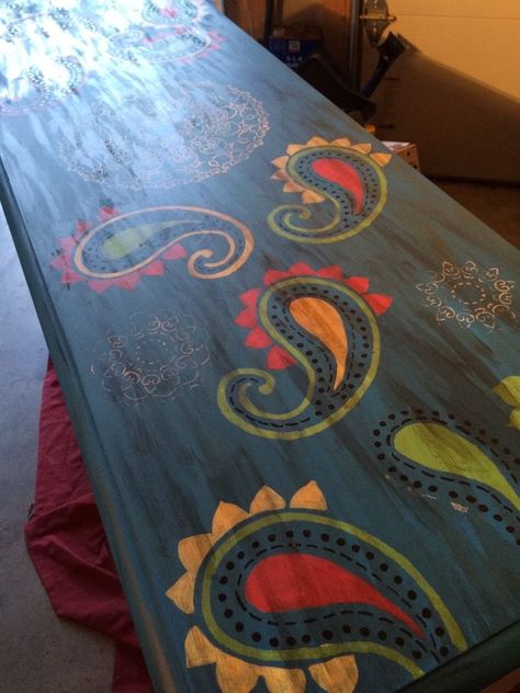 This is the after pic a beautiful colorful bohemian style table . This table started its life as the bottom of a very traditional hutch . Here is the before pic , honestly I love it but the very special lady " my sister Rachel " wanted a bohemian style entry table for her new apt. I started with a door I painted it a deep red ,yellow , and blue it wasn't dark enough so I went over it with brown wax . After I got the OK I went stencil crazy here is the door I stenciled with a… Mexican Painted Table, Mandala Dining Table, Mexican Painted Furniture Folk Art, Mandala Stained Table, Hand Painted Dressers Bohemian, Boho Style Furniture, Hand Painted Table, Bohemian Colors, Mexican Decor