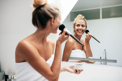 Beautiful young woman applying makeup in bathroom Woman Applying Makeup, Best Foundation For Acne, Natural Looking Makeup, Gel Mascara, Makeup Materials, Light Concealer, Skin Spots, Applying Makeup, Concealer Colors