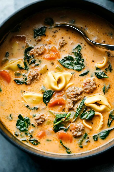 Creamy sausage tortellini soup is a hearty mix of Italian sausage, cheese tortellini, fresh spinach, and rich broth. It's the perfect cozy meal for fall. Crock Pot Sausage And Tortellini Soup, Italian Sausage Recipes With Tortellini, Tortellini Fall Recipes, Creamy Sausage Tortellini Soup With Sweet Potato, Creamy Sausage Spinach Tortellini Soup, Soups Using Tortellini, Sweet Potato Tortellini Soup, Sausage Tortellini Soup Healthy, Italian Sausage Spinach Tortellini Soup