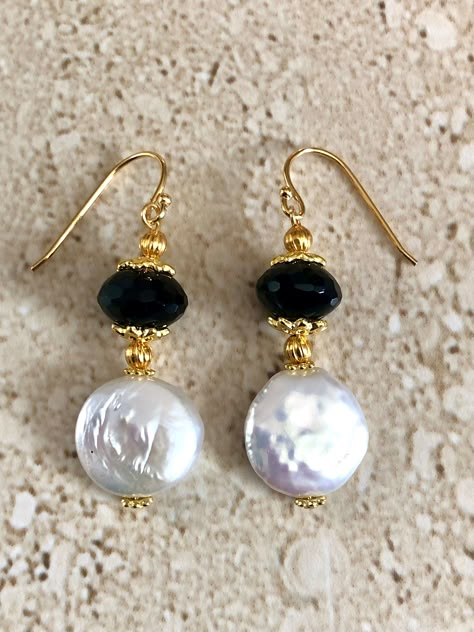 Coin Pearl Earrings featuring a 14mm iridescent coin pearl accented with a 19MM faceted black onyx rondelle stone and gold plated spacers.  Gold Filled ear wires. Earrings measure 1 1/2 inches GIFT BOXED Coin Pearl Earrings, Black And White Earrings, Black Onyx Earrings, Diy Jewelry Necklace, Black Earrings Dangle, Pearl Dangle Earrings, Silver Earrings Handmade, Coin Pearls, Onyx Earrings