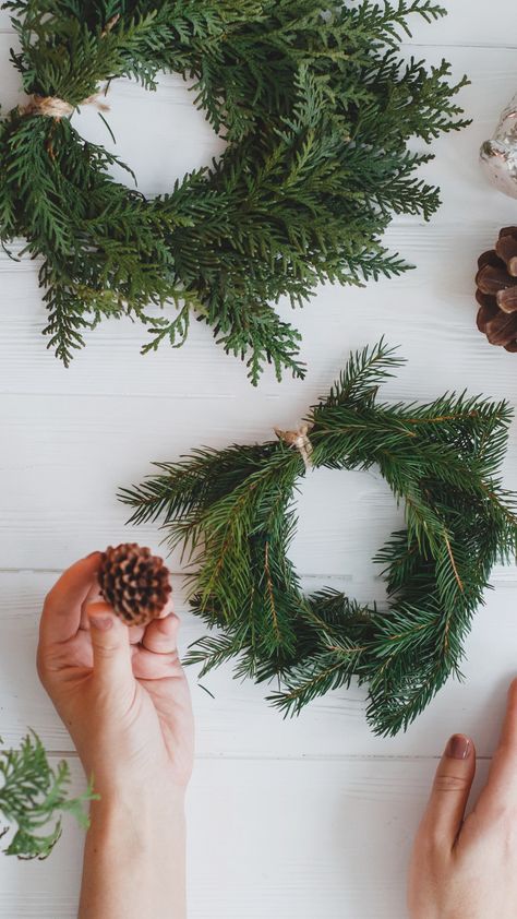 Get inspired by the beauty of winter greenery with these DIY table decor ideas! Create stunning centerpieces by wrapping smaller evergreen branches in a circle and securing them with sisal or burlap cord, or even floral wire. Soft and feathery evergreens like cedar and Douglas fir work wonders for this project. For more holiday simple decor ideas, check out our Natural Simplicity blog post. Greenery Table Decor, Diy Greenery, Simple Decor Ideas, Table Decor Christmas, Winter Greenery, Diy Table Decor, Tree Centerpieces, Rustic Ornaments, Christmas Centerpieces Diy