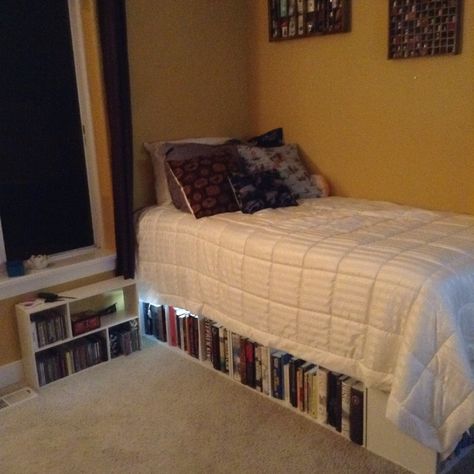 Book shelf Bed ! 5 three tier closet maid square shelf a turned on its sides a sheet of plywood then mattress and if you wish box spring and voila! Bookshelf bed Bed On Top Of Bookshelves, Bed With Bookshelf Underneath, Under Bed Bookshelf, Bookshelves Under Bed, Book Bed Frame, Bookshelf Above Bed Aesthetic, Books Under Bed, Bed Frame Bookshelf, Book Shelf Bed Frame