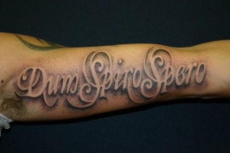 Tattoo Font Ideas for Men Choosing the right font style for your script tattoo as a man can be quite an uphill task. Whether you want a flashy design or a simple minimalistic look, you will be spoilt for choice with the thousands of options available. This tattoo says ‘Dum Spiro Spero’. It is written in a foreign language on the forearm and uses a cursive concept. The background is designed with dots to look spray painted. Tattoos written in other languages are a common practice. Tattoos Letters, Tattoo Writing Styles, Tato 3d, Font Tato, Tattoo Font For Men, Letter Tattoos, Tattoo Quotes For Men, Tattoo Lettering Design, Tattoo Lettering Styles