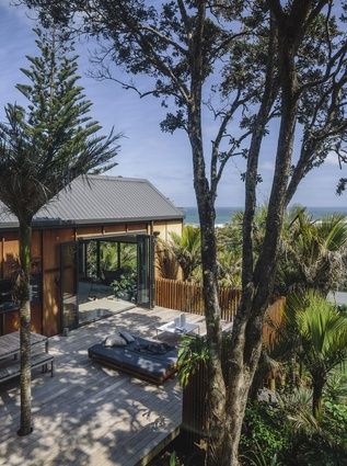 Colours, materials and composition hint at traditional South Pacific buildings. Muriwai Beach, Mid Century Modern Living Room Decor, New Zealand Homes, Resort House, Beach New Zealand, Houses By The Beach, Forest Houses, Ocean Forest, Beach Architecture