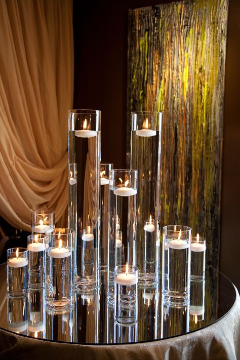 Candlelight, love the clear vases, use of water and candles, but dislike the background in this photo Tall Floating Candle Centerpieces, Candle Theme Wedding, White Silver Party, Bakery Lighting, Adult Mermaid Party, Elegant Party Decor, Lantern Decor Ideas, Talent Show Ideas, Cake Shooters