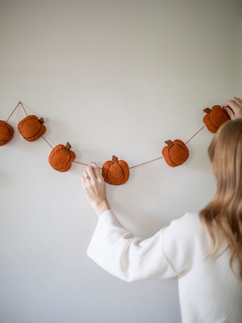 This rustic and sweet Pumpkin Garland is crafted from wool felt, adding an artisanal charm to any space during the harvest season. Perfect for creating a cozy atmosphere in your kitchen or living room. Gather your family and friends in your newly decorated home for a memorable autumnal party! Craft: These cute garlands Felt Crafts Autumn, Autumn Felt Crafts, Autumn Garland Diy, Autumnal Party, Felt Halloween Decorations, Felt Autumn, Autumn Garland, Autumn Diy, Urban Homestead