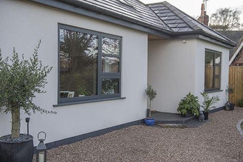 The cool anthracite grey windows stand out beautifully against the white render. #glazing #aluminium #windows #anthracitegrey #bungalow #bungalowrenovation #homeinspo #architecturaldesign #exterior #bungalow #exterior Rendered House Exterior Uk, House With Grey Windows, White Bungalow Exterior, Rendered House Exterior, Anthracite Grey Windows, Rendered House, Contemporary Bungalow, Rendered Houses, House Exterior Uk