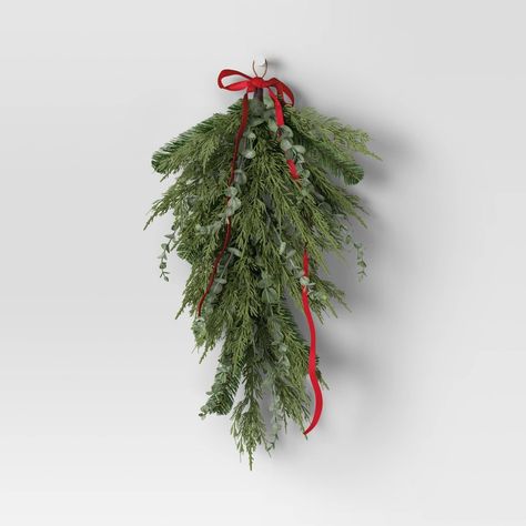 Get into the holiday spirit by decorating your home with this 28-Inch Mixed Greenery with Bow Hanging Christmas Artificial Swag from Wondershop™. Perfect for hanging on the front door, near the entrance or the living room mantel, this unlit swag features mixed greenery with red bow to bring a lovely look to any indoor setting. Plus, it's finished off with a string loop for easy hanging anywhere you please. Welcome to the Wondershop™. Garage Light Christmas Swag, Holiday Door Swag, Holiday Archway Decor, Christmas Pew Decorations, Outdoor Christmas Swag, Christmas Dorm Decorations, Greenery Swag, Archway Decor, Pine Swag