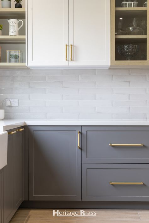 In this kitchen renovation Satin Brass Bauhaus cabinet handles have been beautifully paired with white and grey kitchen cabinets. The golden tones of the hardware are luxurious and eye-catching, adding warmth to the kitchen.   Photography @claudiestrydom White And Grey Kitchen Cabinets, White And Grey Kitchen, Modern Shaker Kitchen, Shaker Kitchen Design, Brass Cabinet Pull, Kitchen Photography, Shaker Kitchen Cabinets, Brass Cabinet Pulls, Bauhaus Design