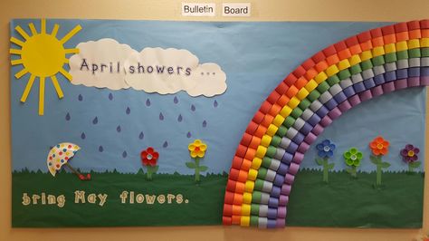 "April showers bring May flowers "bulletin board. The rainbow is made with stapled paper loops and the flowers are hot glued milk lids. Flowers Crafts Preschool, Flower Crafts Preschool, Flower Bulletin Boards, April Bulletin Boards, Sunday School Bulletin Boards, Rainbow Bulletin Boards, Work Bulletin Boards, Halloween Bulletin Boards, Classroom Boards