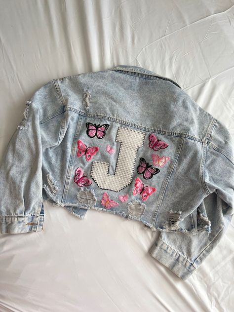 This is a beautiful light denim jacket with a 8” rhinestone J on the back with some pretty pink butterflies. On the front collar are gorgeous pink and blue flowers (size medium) Butterfly Denim Jacket, Butterfly Jean Jacket, Redesigned Clothes, Ash Blonde Hair Balayage, Taylor Swift Costume, Light Denim Jacket, Custom Denim Jacket, Trendy Denim, Custom Denim