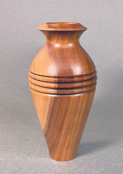 Celebrate the natural elegance of pear wood with this hand-turned vase, a testament to timeless craftsmanship. Its smooth contours and rich, earthy tones capture the essence of minimalist design, making it a perfect addition to any modern home. The vase showcases the unique grain patterns of pear wood, bringing a touch of organic sophistication to your decor. Ideal for displaying fresh blooms or as a standalone piece, this vase is not just a container but a piece of art that complements any spac Wooden Flower Vase, Turned Vase, Wooden Workshops, Turned Art, Pear Wood, Into The Wood, Wood Turner, Easy Wood Projects, Wood Carving Designs