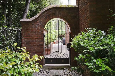 Stroll through the property’s lush gardens and landscape. Photo: Dennis Mayer Fence Brick, Arch Gate, Brick Archway, Brick Face, Outdoor Fence, Modern Fire Pit, Arch Doorway, Wall Outdoor, Brick Arch