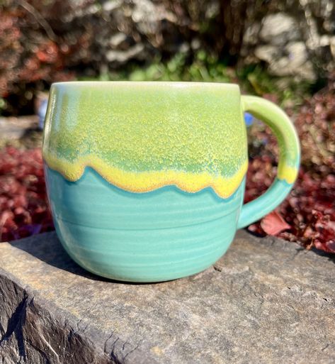 "Welcome to Kingfisher Potters!  This beautiful light wheel-thrown stoneware mug is glazed using turquoise and yellow glazes.  The blue drip glaze gives each mug an individuality while also being a member of a beautiful set.  Both glazes are food safe and microwave safe.   Due to the nature of the yellow drip glaze the image represents the style and color of the piece. The exact item shipped to you will vary slightly in pattern markings. The process for making these mugs is multi-stepped and individualized.  First the form of the mug is thrown using a stoneware clay on the wheel.  The handle is pulled separately and then attached.  The piece once all the parts are formed is left to dry and then bisque fired.  The bisque fired pots are dipped in the turquoise glaze and left to dry.  Finally Glaze Ideas For Pottery, Pottery Glaze Ideas Color Combos, Pottery Glazing Ideas, Ceramic Glaze Ideas, Pottery Glaze Ideas, Pottery Mugs Handmade, Colourful Pottery, Glazed Mugs, Ceramic Handles