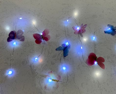 A decorative string of beautiful multi color sheer butterflies and 7 foot stunning LED string lights. These beautiful fairy lights are powered by AA batteries - not included, you can decorate anything you like. The butterflies can placed on railings or decorate your bedroom. Butterflies sheer material - suitable for indoor. Garland butterfly (3.0) Butterfly Party Decor, Palm Tree Lights, Pineapple Lights, Butterfly Party Decorations, Butterfly Garland, Led Garland, Butterfly Mirror, Led Fairy String Lights, Butterfly Lighting