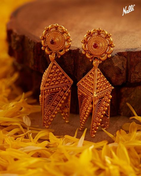 The exquisite gold filigree cutwork Jhumkas! This jhumka is uniquely designed in a circular stud with a triangular-shaped jhumka with sharp geometric cutwork cross lines hanging and crafted in antique pure gold to perfection. A one-of-a-kind jhumka for conventional styling. Explore the glorious heritage of gold jewellery from our latest collection and sparkle this festive season. Jewelry Product Shots, Indian Jewellery Design Earrings, Gold Earrings For Women, Indian Jewellery Design, Gold Jewellery Design Necklaces, Jewelry Picture, Jewelry Design Earrings, Gold Earrings Designs, Jewelry Design Necklace