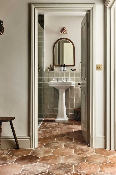 See the medditeranian inspired terracotta effect floor tiles complemented seemlessly by delicate mossy green bathroom tiles