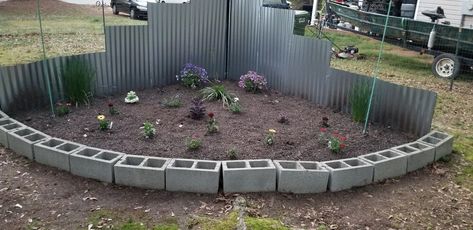 Triangle flower bed made from reclaimed cinderblocks and mulch I've been working with on. Cost will depend on what cinderblocks or bricks used for the front, how big the flower bed is, and how much soil/dirt has to be purchased. I'm putting the actual cost I've put put of pocket but it could be more or less. Triangle flower bed    Second year of the flower bed. I've added more and different plants. As they fill in over this season it will look even better. I've found out not all plants… Triangle Flower Bed Ideas, Triangle Flower Bed, Flower Bed Diy, Flower Beds Diy, Partial Shade Plants, Green Fence, Garden Stepping Stones, Diy Porch, Bed Diy