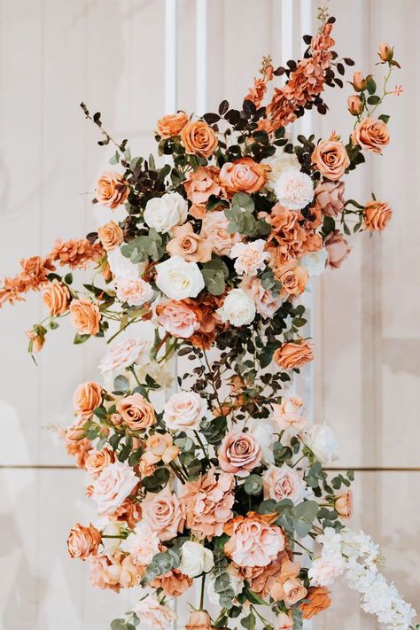 Assorted roses in white, burnt orange and pink with silver dollar, make up this flower arrangement for the flower pedestal decoration used on the main stage. Dusty Orange Wedding Theme, Blush And Burnt Orange Wedding, Orange Pink Flower Arrangements, Burnt Peach Wedding Theme, Orange And Peach Wedding Flowers, Orange And White Wedding Theme, Peach And Dark Green Wedding, Peach And White Flower Arrangements, Terracotta Flower Arrangements