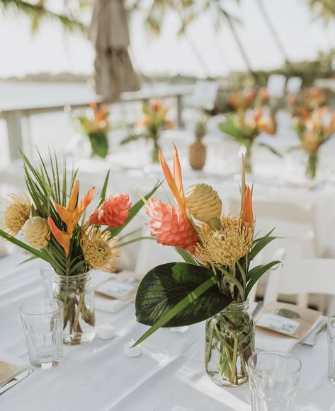 Mason Jar Tropical Centerpieces, Tiki Wedding Centerpieces, Tropical Floral Arrangements Simple, Tropical Floral Table Arrangements, Tropical Flower Table Arrangements, Railing Decorations Party, Hanging Flower Lights, Small Tropical Floral Arrangements, Tropical Boho Centerpiece