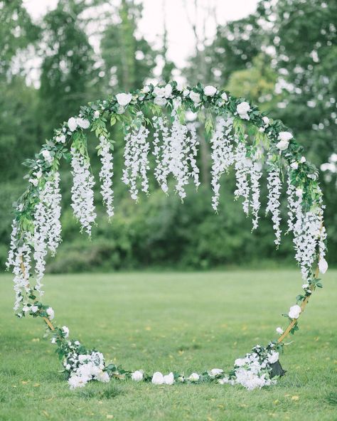 How gorgeous is this stunning circular arbor! Its unique design created a breathtaking focal point for the ceremony, beautifully adorned with white florals and greenery. The combination of blooms and foliage added a touch of romance and elegance, making it the perfect backdrop for the couple's vows. Round Arch For Wedding Ceremony, Circular Arbor, Wedding Arch Circle, Arbor Decor, Circle Arch, Round Arch, Beautiful Wedding Flowers, Flower Circle, Wedding Flowers Summer