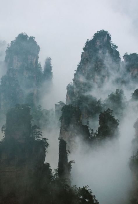 WULINGYUAN, China: is noted for more than 3,000 quartzite sandstone pillars & peaks, many over 660 ft in height, along with ravines, gorges, streams, pools, & waterfalls. It features 40 caves, many with large calcite deposits, & two natural bridges, Xianrenqiao (Bridge of the Immortals) & Tianqiashengkong (Bridge Across the Sky). Wulingyuan forms part of the Wuling Mountain Range, which formed by 700 million years ago. Mountains In China, Mountain Kingdom Aesthetic, Immortality Aesthetic, China Mountains, Ancient China Aesthetic, Mountain Kingdom, Kunlun Mountains, Dragon Mountain, Chinese Bridge