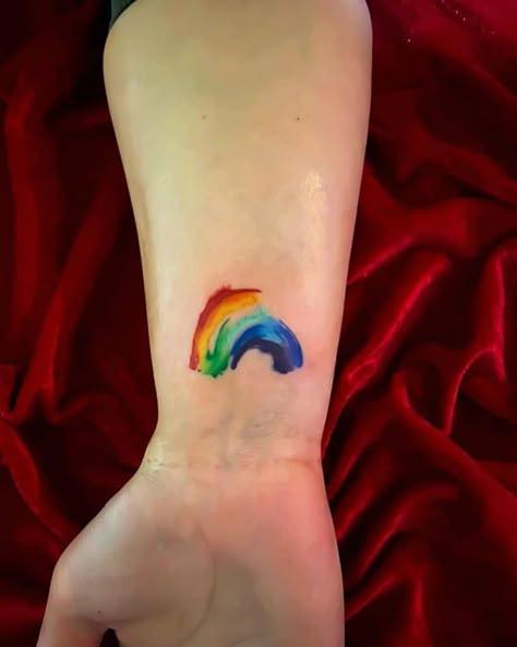 Watercolor Rainbow Tattoo Rainbow Elephant Tattoo, Rainbow Tattoo Watercolor, Rainbow Wave Tattoo, Christian Rainbow Tattoo, Rainbow Dinosaur Tattoo, Watercolor Name Tattoo, Gay Tattoo For Women, Minimalist Rainbow Tattoo, Rainbow Tattoo Ideas Unique