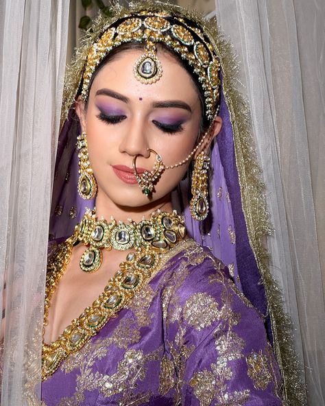 𝗣𝗿𝗲𝘀𝗲𝗻𝘁𝗶𝗻𝗴 𝗥𝗲𝗸𝗵𝗮 𝗠𝗮𝗻𝗴𝗮𝗹’𝘀 𝗕𝗿𝗶𝗱𝗲 💜 The Maharani Look—a celebration of heritage, power, and elegance. This timeless bridal look embraces minimalism, with makeup that highlights the natural beauty of the bride. The eyes are the focal point, adorned with a striking blend of purple and violet gradation, creating a bold yet graceful statement. Complemented by soft, pink nude lips, this look captures regal sophistication, perfect for the modern-day queen.👸 👑 (Bridal makeup, indore makeup artist, l... Purple Saree Makeup Look, Purple Outfit Makeup Indian, Transitional Purple Lehenga For Wedding, Purple Lehenga Bridal, Lavender Lehenga Makeup, Purple Lehnga Makeup Look, Purple Lehenga, Bridal Eye Makeup, Nude Lips