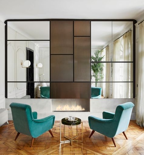 A Mondrian-inspired mirrored wall custom designed by Laura Gonzalez features central panels in bronze metal above a concrete fireplace base. | archdigest.com Modern Mirror Design, Farmhouse Fireplace, Rustic Fireplaces, Mirrored Wall, Mirror On The Wall, Kitchen Fireplace, Work Room, Parisian Apartment, Gallery Walls