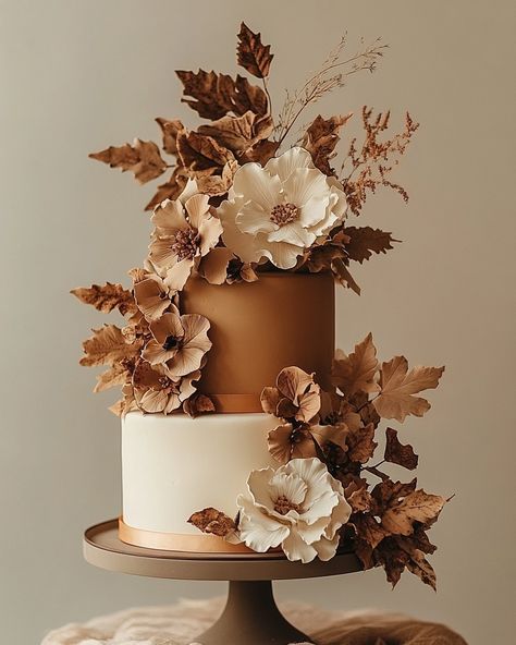 Celebrate the beauty of the fall season with this enchanting autumn-inspired wedding cake. Featuring rich, earthy tones of burnt orange, copper, and cream, this two-tiered masterpiece is adorned with delicate sugar flowers and foliage that perfectly capture the essence of the season. The textured leaves and flowers create a stunning contrast against the smooth fondant finish, making this cake a perfect centerpiece for rustic or nature-inspired weddings. Embrace the warmth and charm of autumn ... Brown Wedding Cakes, Autumn Wedding Cake, Rustic Autumn Wedding, Autumn Wedding Cakes, Wedding Couture, Enchanting Wedding, Earthy Wedding, Rustic Autumn, Orange Copper