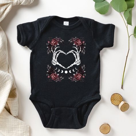 An adorable heart in skeleton hands and gothic flowers make this a sweet and emo bodysuit. Perfect for a grungy edge! * Q U I C K * F A C T S * ✺ 100% ringspun cotton ✺ Light fabric ✺ plastic snaps closure  ✺ Inside out and wash and dry normally (on cool for best results). Do not iron decoration. ✺ printed using DTG Direct to Garment printing.  ✺ Colors may vary due to computer monitors and printing inks. ✺ While we offer several shirt colors some may have a better contrast with the design. Keep that in mind when choosing your color.  * S I Z I N G * ✺ Sizing is unisex  ✺ Size guide and fit: Please see size charts in photos for guidance on sizing to ensure the best fit.  ✺ The best way to find your size is to measure a shirt you own that fits you well and compare that to the size on the ch Grunge Baby Outfits, Skeleton Baby Shirt, Gothic Baby Clothes, Alternative Baby Clothes, Goth Baby Clothes, Clothes Pastel, Skeleton Baby, Goth Dark Academia, Soft Goth