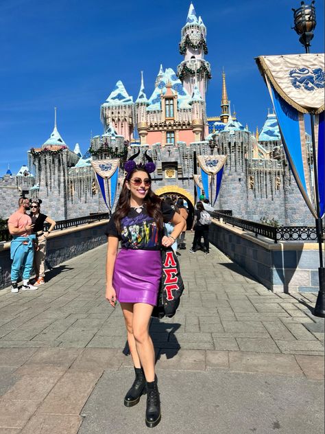 A woman posing in front of the Disneyland castle wearing maleficent ears, a Disney villains t shirt, a purple skirt and doc martens. Mal Disneybound, Maleficent Disneybound, Maleficent Outfit, Ariel Movie, Amusement Park Outfit, Disney Bound Outfits Casual, Scary Party, Goth Disney, Theme Park Outfits