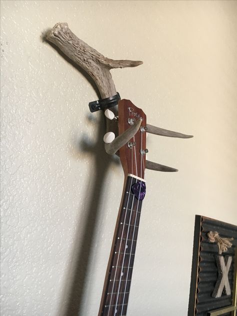 DIY ukulele/guitar hang. Made from deer antler and spray painted hose bracket! Guitar Hanger Ideas, Guitar Holder Wall Diy, Ukulele Holder Diy, Diy Ukulele Hanger, Diy Guitar Wall Hanger, Ukulele Holder, Antler Guitar Hanger, Deer Antler Ideas, Hanging Guitars