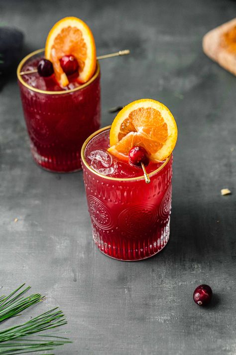 This Cranberry and Orange Juice Mocktail is the perfect non-alcoholic drink for the fall and holiday seasons. With a touch of maple syrup and an easy-to-make fruit garnish, it makes any occasion feel like a celebration. Any non-drinkers and kids at a party will love feeling included when they get to have a fancy drink! Fall Drinks Nonalcoholic For Party, Friendsgiving Drinks Nonalcoholic, October Mocktails, Red Drinks Non Alcoholic, Holiday Mocktails Non Alcoholic, Cranberry Orange Mocktail, Holiday Drinks Nonalcoholic, Winter Mocktails Non Alcoholic, Thanksgiving Mocktail Recipe