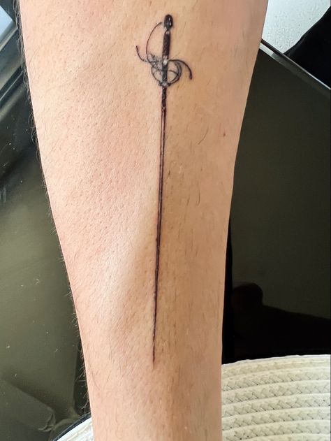 Rapier tattoo men tattoo sword tat Rapier Tattoo, Greek Swords Tattoo, Saber Tattoo, Theatre Tattoos, Small Swords Tattoos, Minimalist Tattoo Swords, Swords Crossing Tattoo, Edgy Tattoos, Longsword Tattoo