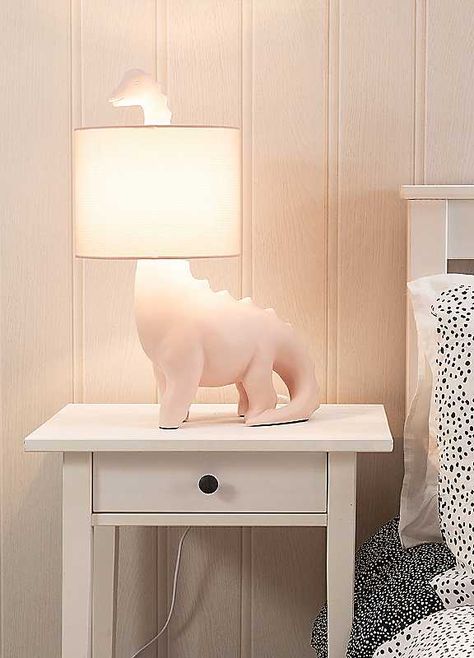 Brighten up your little ones space with this dinosaur shaped table lamp. The ceramic base comes in a pink or green finish with a matching braided flex and fabric drum shade. Give your child's bedroom a pop of colour in a subtle and fun way. The in-line rocker switch provides convenient control, making it easy to illuminate your space. Help your child overcome the fear of darkness and create a comfortable sleep environment with this playful lamp. Brand: ValueLights Ceramic Dimensions approx. 26 x Girly Dinosaur Room, Space Dinosaur Nursery, Pink Dinosaur Nursery, Girls Dinosaur Bedroom, Pink And Green Room Decor, Girl Dinosaur Room, Girls Dinosaur Room, Dinosaur Bedroom Ideas, Playful Lamp