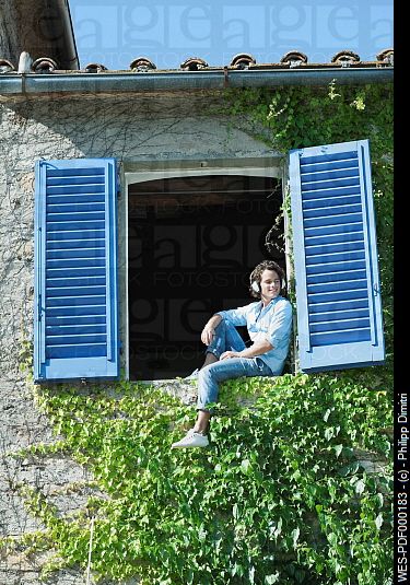 Italy, Tuscany, Young man sitting on window sill with shutters Person Sketching, Sitting On Window Sill, Sitting On Window, Arched Cabin, Window Drawing, Photo Window, Italy Tuscany, Summer Painting, Body Reference Drawing