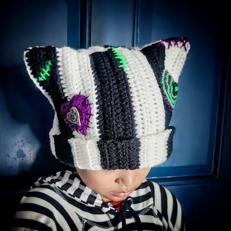 Handmade crochet cat beanie with cat ears with ribbing, buttons, and stitching details. Size: For elderly emo heads 21+ inch in circumference. May fit emo child's head loosely. Length is 9-10 inches long for folding outwards if preferred. Color: black and white stripes with purple and bright green details. Color may vary slightly due to monitor settings. Stitch design and placements may vary slightly as each one is handmade by moi. Materials: acrylic yarns (stretchy) and buttons  Made to order i Sally Nightmare Before Christmas Hat, Cat Ear Hats Crochet, Crocheted Halloween Hats, Shark Beanie Crochet, Crochet Square Hat Pattern Free, Odd Crochet Patterns, Tapestry Crochet Hat, Halloween Crochet Beanie, Crochet 1 Skein Projects