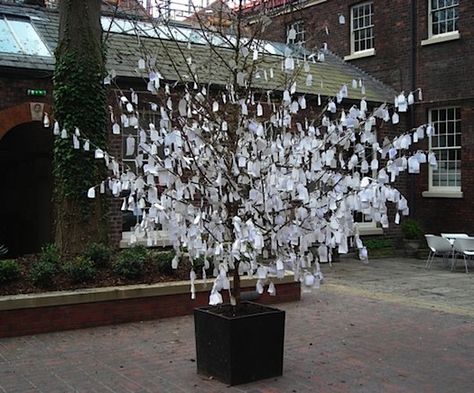 One of the most compelling trees we’ve seen in a public space is Yoko Ono‘s Wish Tree, versions of which have been installed around the world. She conceived of the idea in 1996 – though it’s actually an a very old practice – and it continues to reverberate. People are invited to write their wish on a paper tag and tie it to the tree. It can be done with any tree, anywhere, with any group of people. It’s much more powerful than a wishing well, maybe because you can read other people’s wishes. Wish Tree, Light Up Tree, Memory Projects, Tree Tags, Wishing Tree, Tree Base, Yoko Ono, Nature Table, Tree Wedding