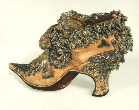 Shoe that belonged to King of France, Louis XIV, also known as the Sun King. He was responsible for the design and construction of Versaille, so naturally one would expect his shoes to be equally ornate!. This shoe is covered with silk, as were most shoes of European aristocrats/royalty. It is also covered with metallic lace, specifically lace made of silk thread that was wrapped with real silver soil. Thus, the silver has tarnished and the lace looks dark gray and brown. 18th Century Shoes, Century Shoes, Historical Shoes, Old Shoes, Century Clothing, Antique Clothing, Louis Xiv, Desert Boots, Historical Clothing