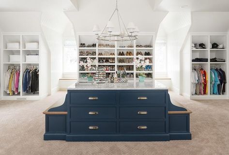 This spacious walk-in closet boasts an eye-catching navy blue island fitted with built-in benches with stained wood seats and accented with chrome cup pulls and a gray marble countertop illuminated by a ring chandelier. Dresser With Marble Top, Built In Benches, Grey Bunk Beds, Blue Closet, Island Dresser, Transitional Closet, Mirrored Wardrobe Doors, Blue Kitchen Island, Contemporary Closet