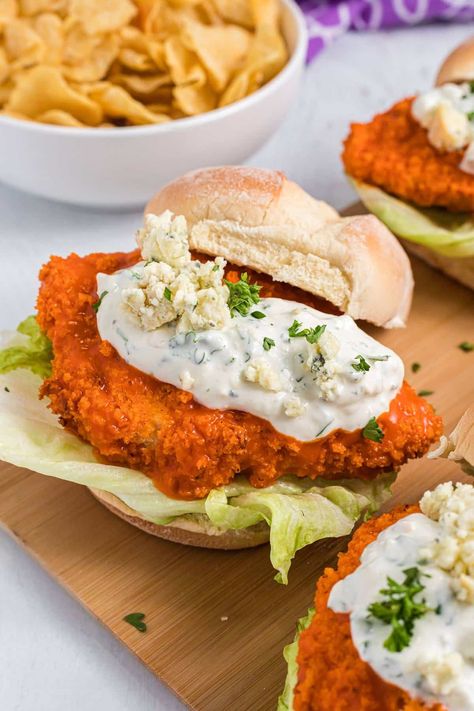 Spicy buffalo chicken sandwiches topped with crispy lettuce and a creamy blue cheese dressing. The crispy chicken is coated in panko and then baked. Dip them in buffalo sauce to give them a spicy kick! Pop over to my site for the recipe! | dinner ideas | chicken recipes | sandwich recipes | Baked Spicy Chicken Sandwich, Buffalo Chicken Sandwich Crispy, Crispy Buffalo Chicken Sandwich, Spicy Buffalo Chicken Sandwich, Baked Dip, Buffalo Chicken Sandwich, Enchilada Sauce Easy, Spicy Buffalo Chicken, Boiled Chicken Breast