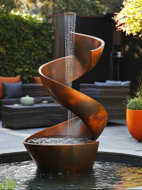 A modern, artistic garden fountain with a quirky design, featuring cascading water flowing through uniquely shaped metal elements, set in a lush, contemporary garden setting. Fountain For Home Garden, Modern Fountains Outdoor, Recycled Barrel, Fountain For Home, Barrel Fountain, Contemporary Gardens, Modern Fountain, Outdoor Fountains, Home Gardens