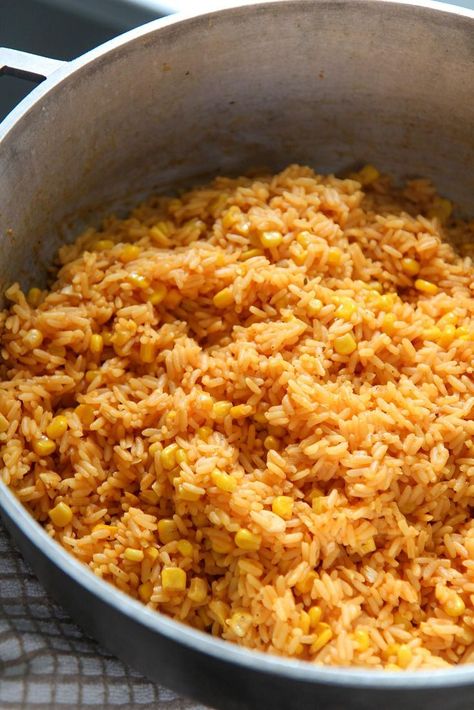 This yellow rice with corn is cooked with onions, garlic, spices, and vino seco. A Cuban staple that can be enjoyed with tomato avocado salad and pernil. Super easy to make and will feed a large crowd. #sidedish #yellowrice Rice With Corn Recipe, Rice And Corn Recipe, Spicy Corn Dip, Rice With Corn, Yellow Rice Recipe, Rice And Corn, Yellow Rice Recipes, Parboiled Rice, Seasoned Rice Recipes