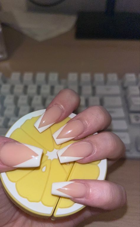 coffin shaped acrylic nails with a v shape white tip, holding a lemon to show them off. French Tip Nails Coffin Medium Length, V Tip White Nails, White Acrylic Nails Medium Length, V Shape French Tip Nails Short, French Tip Nails V Shape, V Line Nails, V Shape French Tip Nails, V Tips Nails Coffin, Coffin Chrome Nails