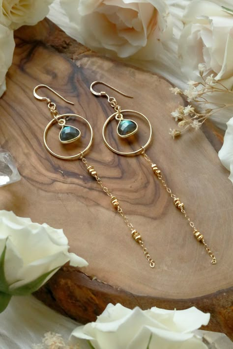 Our new Starlight Labradorite Gold Earrings are our next anticipated bestsellers with stunning flashy Labradorite gems cascading from golden hoops, chain, and beads. A sweet connection to the cosmos the Starlight Earrings represent inner knowing, infinite potential and endless dreams. Starlight Labradorite Gold Earrings are handcrafted with 14k Goldfilled + Gold Vermeil components, chain, and beads. 14k Gold Vermeil flashy Labradorite bezel. 14k Goldfilled Ear Wire. Hangs 3.625 inches long from top of ear wire. _____________________________ LabradoriteLabradorite, in striking hues ranging from deep blue and gray to iridescent flecks of green and gold, is thought by ancient cultures to have descended from the Aurora Borealis. Labradorite is both mystical and otherworldly, imbued with esoter Inner Knowing, Bezel Jewelry, Golden Hoops, Handmade Jewelry Tutorials, Earrings Inspiration, Handmade Wire Jewelry, Funky Jewelry, The Cosmos, Bijoux Diy