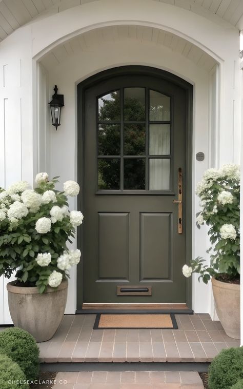 If you’ve ever daydreamed about walking up to the perfect front door—one that looks like it belongs in a cozy countryside movie where the main character has impeccable taste—then welcome to your new obsession. The arched shape? Iconic. The subdued green paint?  perfection. And let’s talk about that vintage-inspired door knocker—the kind that makes you want to send handwritten letters and bake fresh bread, even if your current reality is more “Amazon Prime and DoorDash.” And the best part? You can bring the same energy to your own home with a few intentional updates. Think soft neutral tones, classic hardware, and an arched silhouette that instantly elevates your curb appeal. And yes, this is your sign to repaint your front door immediately. Cottage Doors Front Entrance, Front Door Aesthetic, Cozy Cottage Interiors, Cottage Front Door, Cottagecore Cabin, Modern Cottage Homes, Cottage Front Doors, Front Door Inspiration, Cabin Vibes